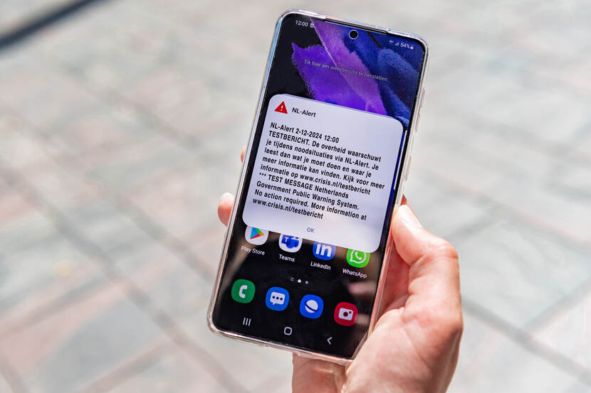 Een NL-Alert testbericht op een mobiele telefoon. Het bericht zegt het volgende: NL-Alert 2-12-2024 12:00 TESTBERICHT. De overheid waarschuwt je tijdens noodsituaties via NL-Alert. Je leest dan wat je moet doen en waar je meer informatie kan vinden. Kijk voor meer informatie op www.crisis.nl/testbericht *** TEST MESSAGE Netherlands Government Public Warning System. No action required. More information at www.crisis.nl/testbericht