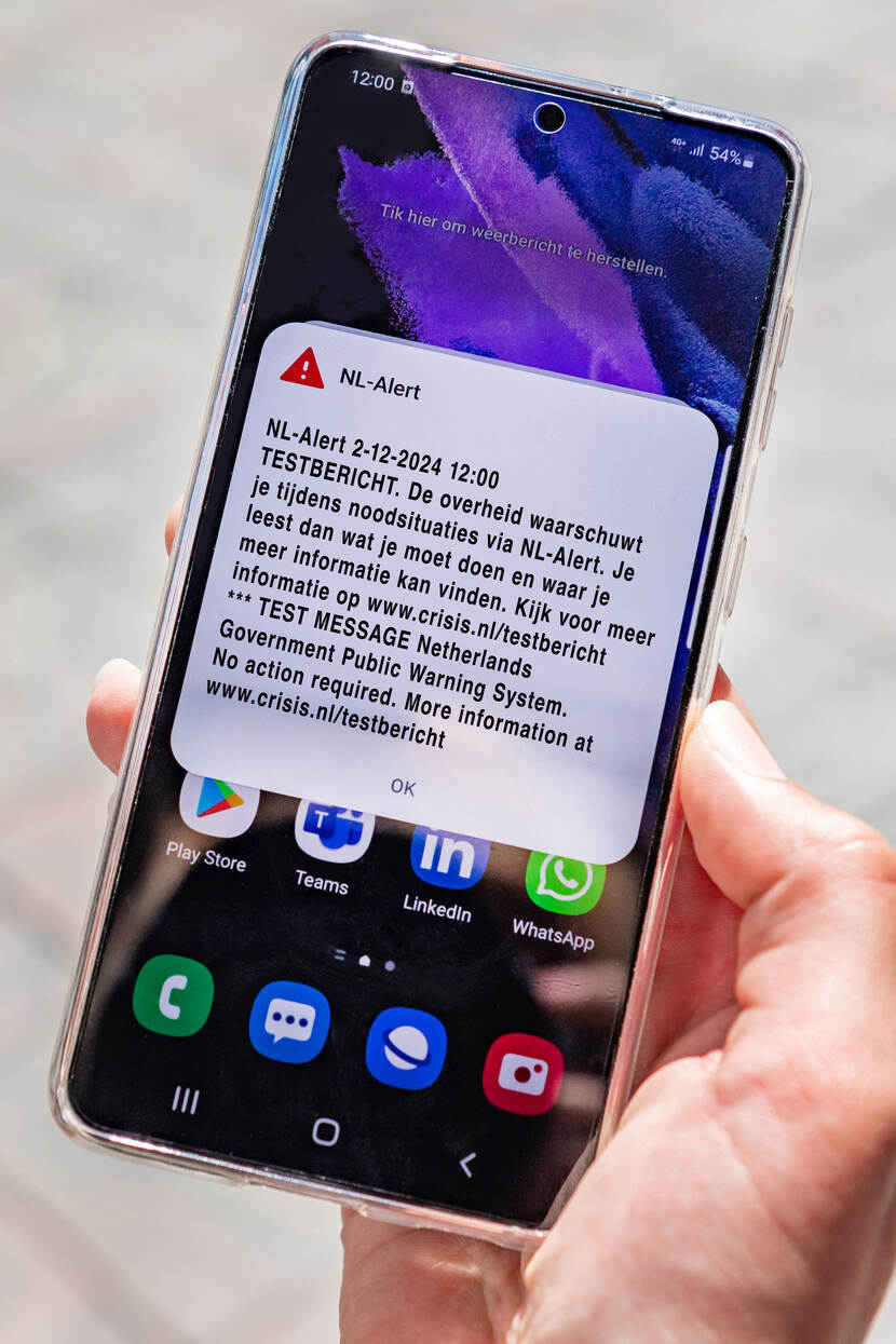 Een NL-Alert testbericht op een mobiele telefoon. Het bericht zegt het volgende: NL-Alert 2-12-2024 12:00 TESTBERICHT. De overheid waarschuwt je tijdens noodsituaties via NL-Alert. Je leest dan wat je moet doen en waar je meer informatie kan vinden. Kijk voor meer informatie op www.crisis.nl/testbericht *** TEST MESSAGE Netherlands Government Public Warning System. No action required. More information at www.crisis.nl/testbericht